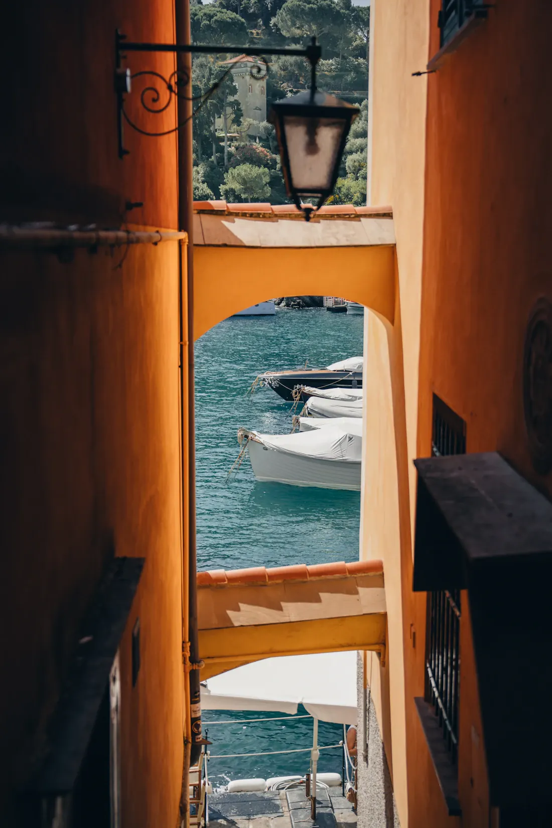 Un pasaje de paredes cálidas deja ver el puerto de Portofino, en Italia.
